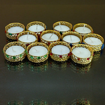 Gold candle holders with white candles on a reflective surface