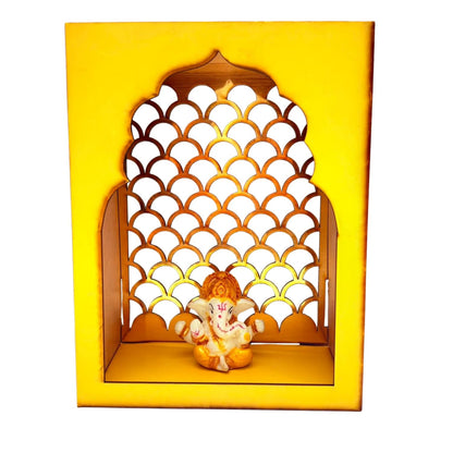 A decorative Ganesha wall niche display featuring a small Ganesha figurine seated inside a yellow arched wooden frame with a scalloped cutout pattern, shown against a plain white background.