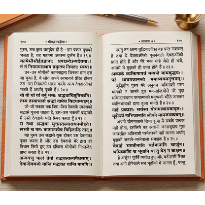 An open vintage-style book with printed Hindi text on both pages, photographed against a dark background with a gold decorative object in the upper right corner.