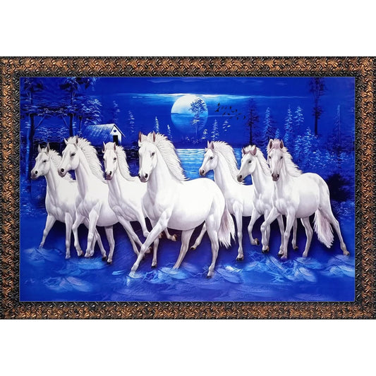 A framed wall art piece depicting a group of white horses running through a snowy night landscape under a full moon, with a decorative brown ornate frame around the artwork.