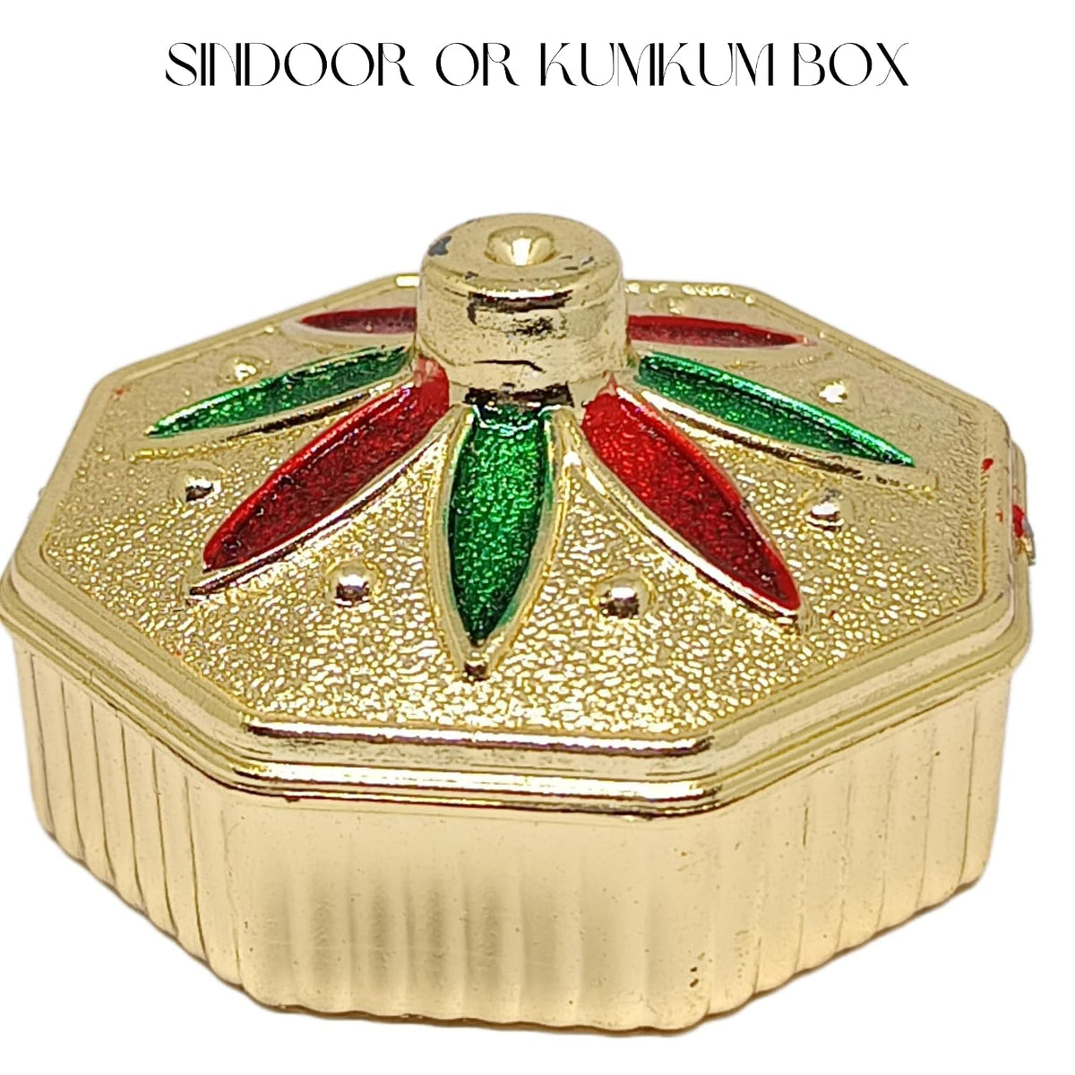 A gold-colored octagonal box with a textured lid, featuring red and green glittery petal designs on top. The text 'SHIDOOR OR KUMIKUM BOX' is written at the top of the image on a white background.