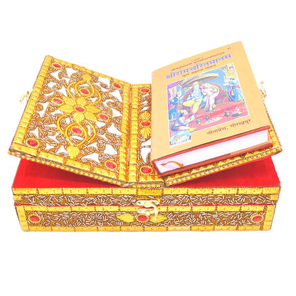 An ornate gold and white decorative book-shaped box with red accents, shown open with a colorful book resting on top, photographed on a plain white background.
