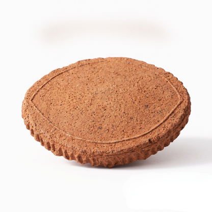 A round, textured brown ceramic tile or coaster with a raised decorative border, shown on a plain white background.